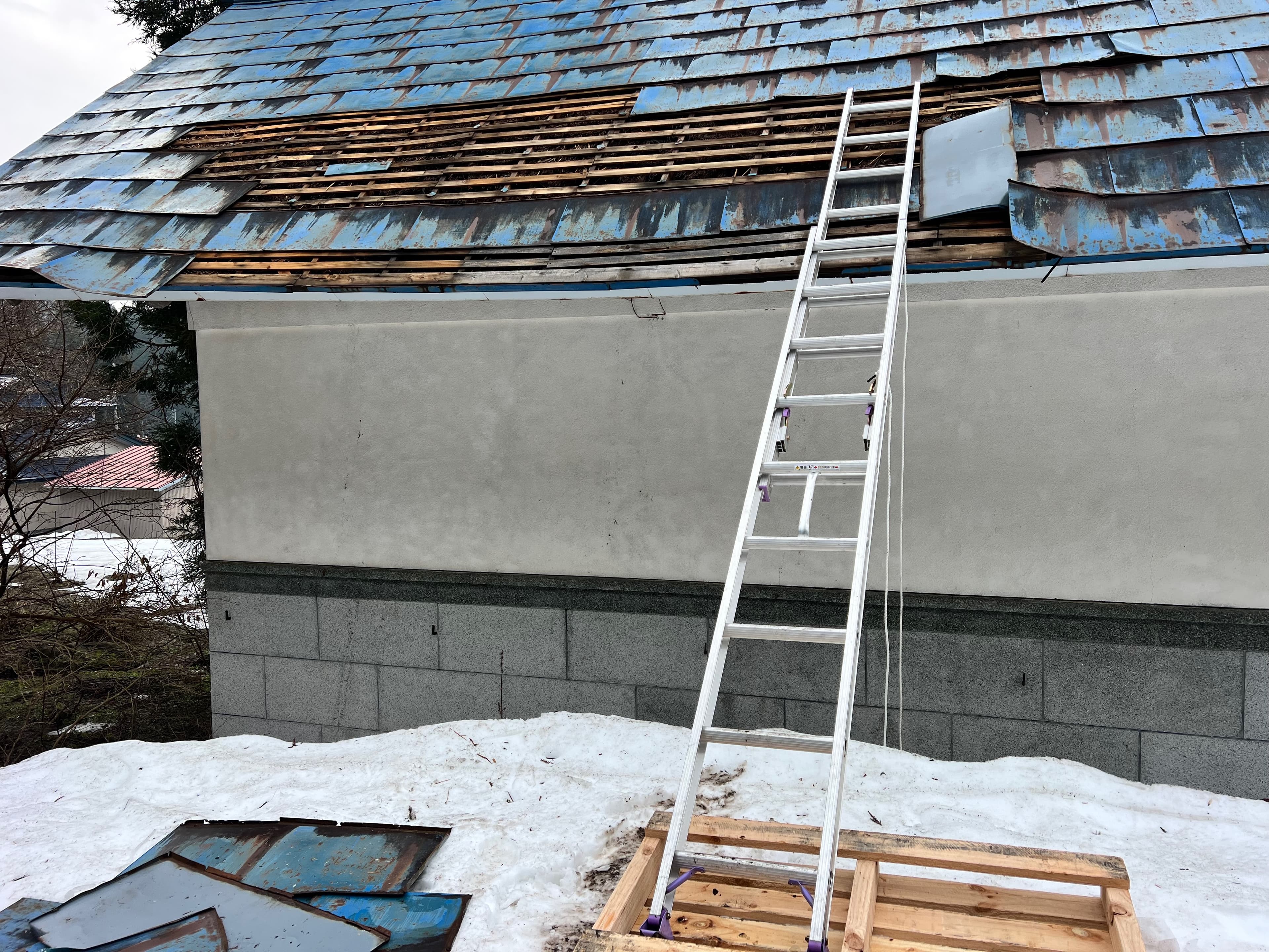 The kura roof — exposed timber beyond one person's repair