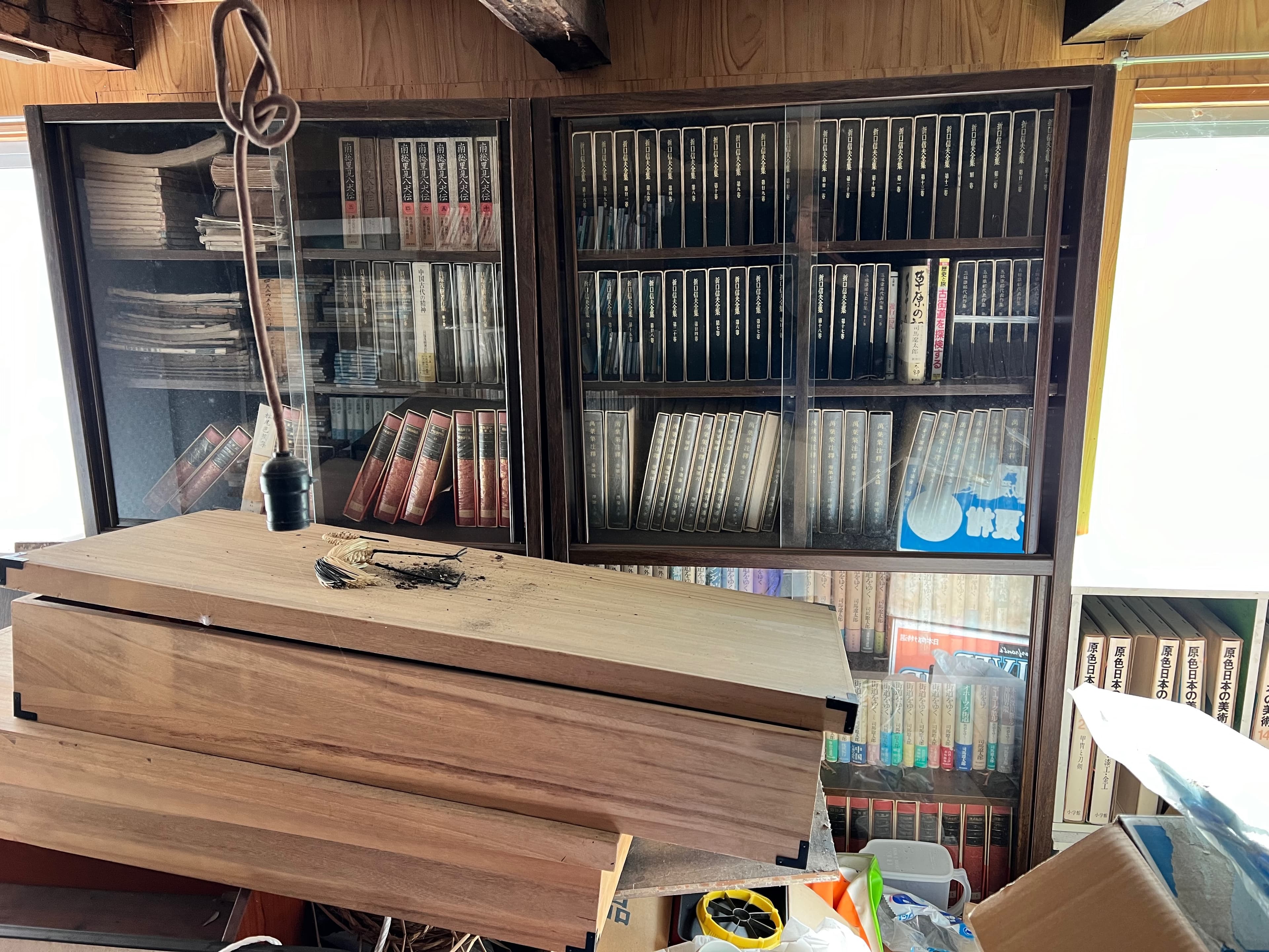 Sealed room behind the jammed door — books and accumulated objects
