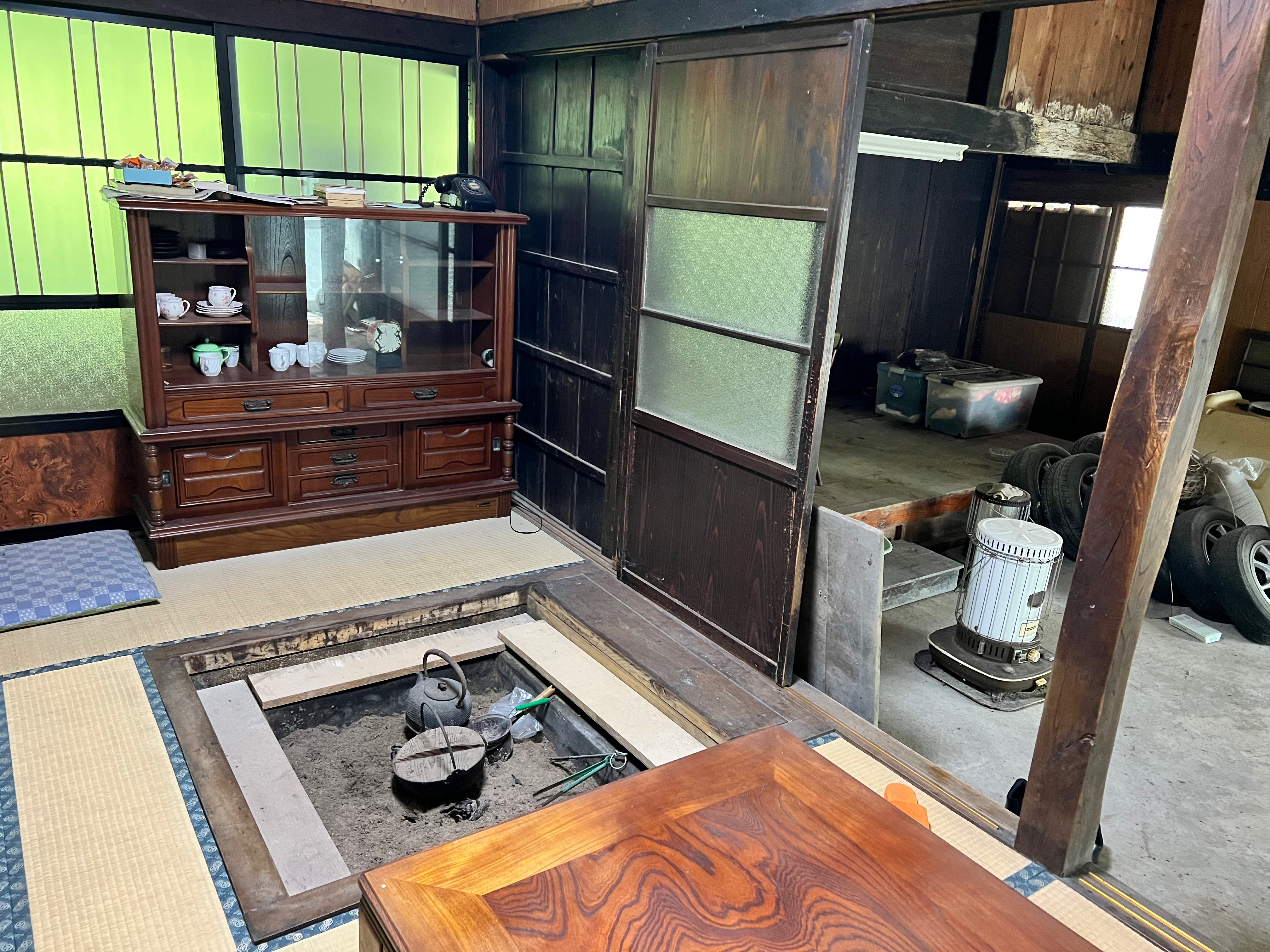Iron kettle resting over the irori hearth — the heart of the main house